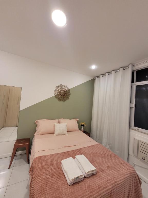 a bedroom with a large bed with two towels on it at Apê Jade, 400 m da praia de Copacabana in Rio de Janeiro