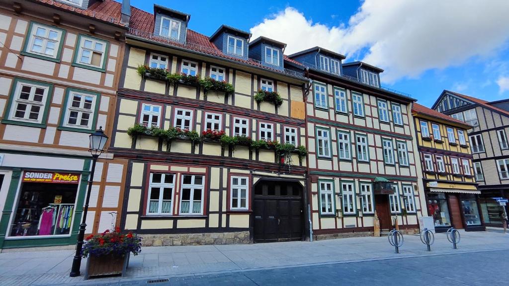 - un grand bâtiment dans une rue avec des fleurs en face dans l'établissement Traditions - Hotel "Zur Tanne", à Wernigerode