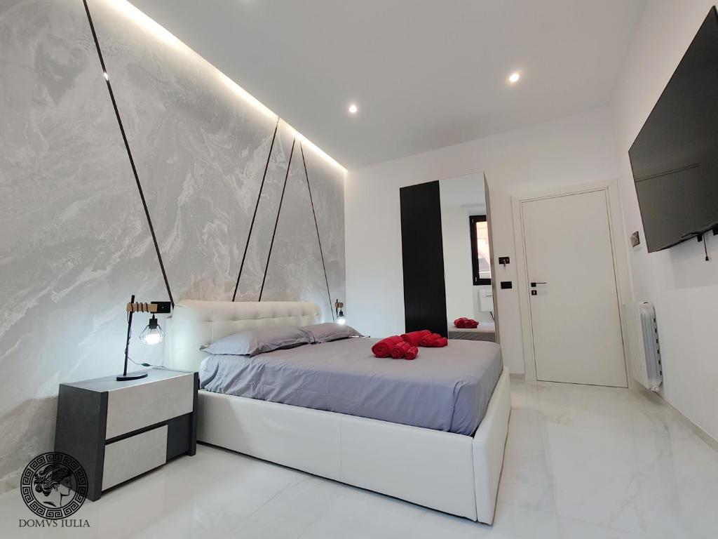 a white bedroom with a bed and a mirror at Domus Iulia - Colosseo in Rome