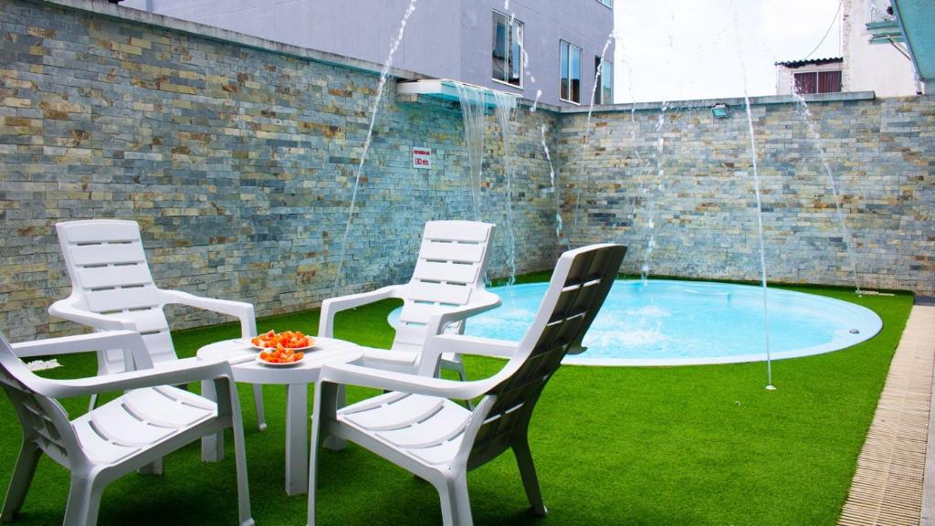 a group of chairs and a table and a pool at HOTEL PLAZUELA REAL in Bucaramanga