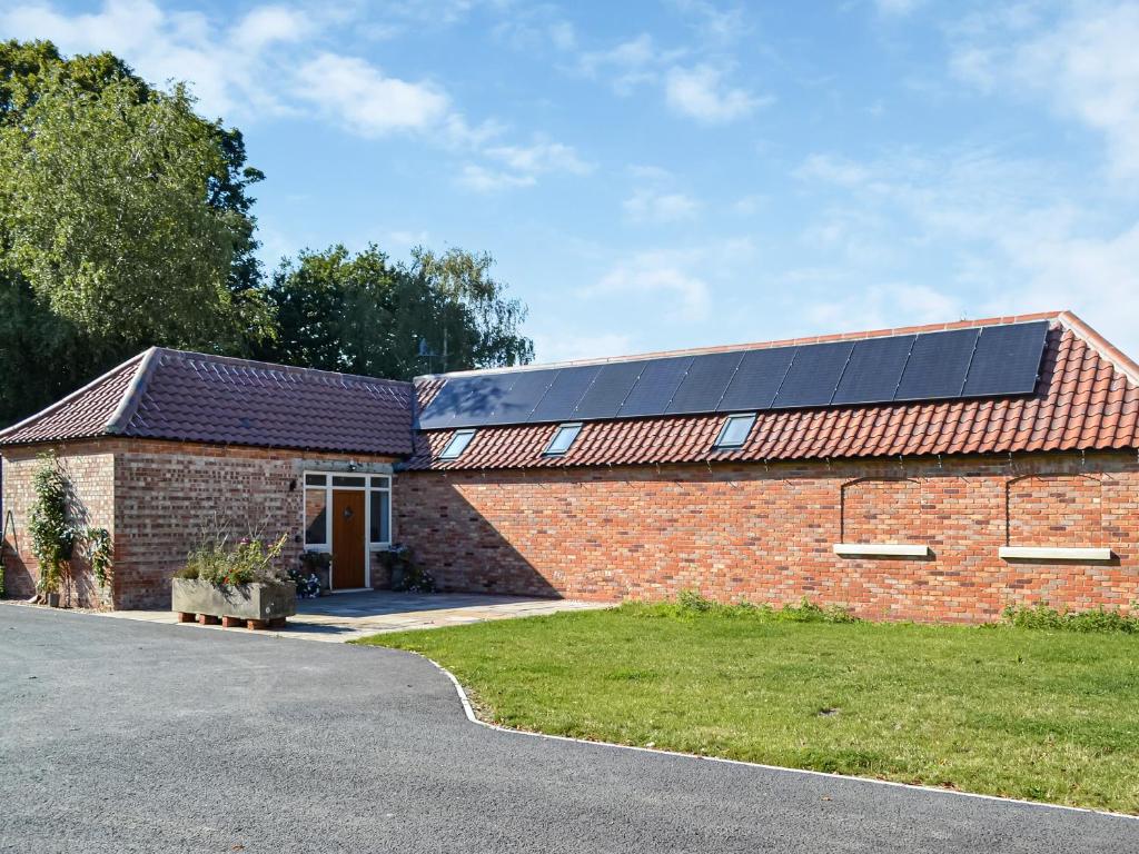 a brick building with solar panels on its roof at The Old Greenhouse - Uk45328 in East Barkwith