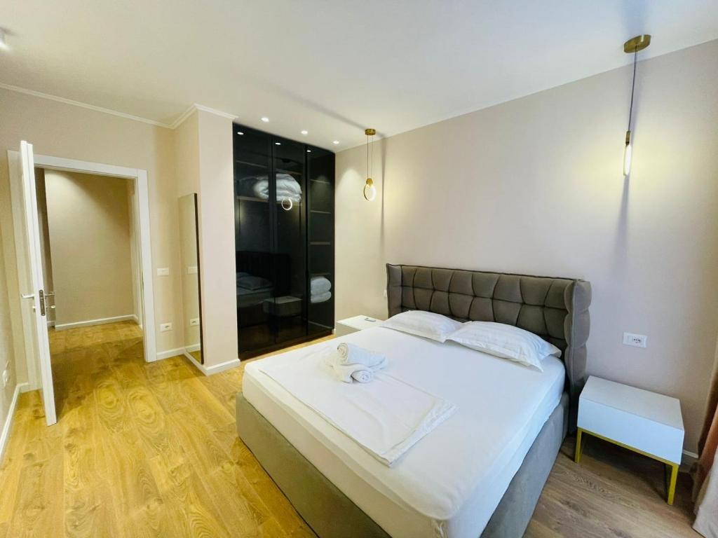 een slaapkamer met een groot wit bed en een glazen deur bij Apartments Premium Center Tirana in Tirana