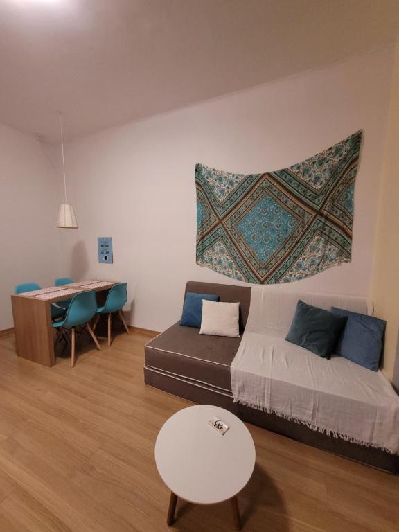 uma sala de estar com uma cama e uma mesa em Apê Turquesa, 190 m da praia do Leme no Rio de Janeiro