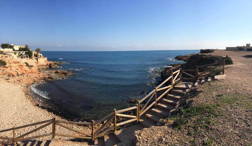 una escalera de madera que conduce al océano en Casa de la playa, en Torrevieja