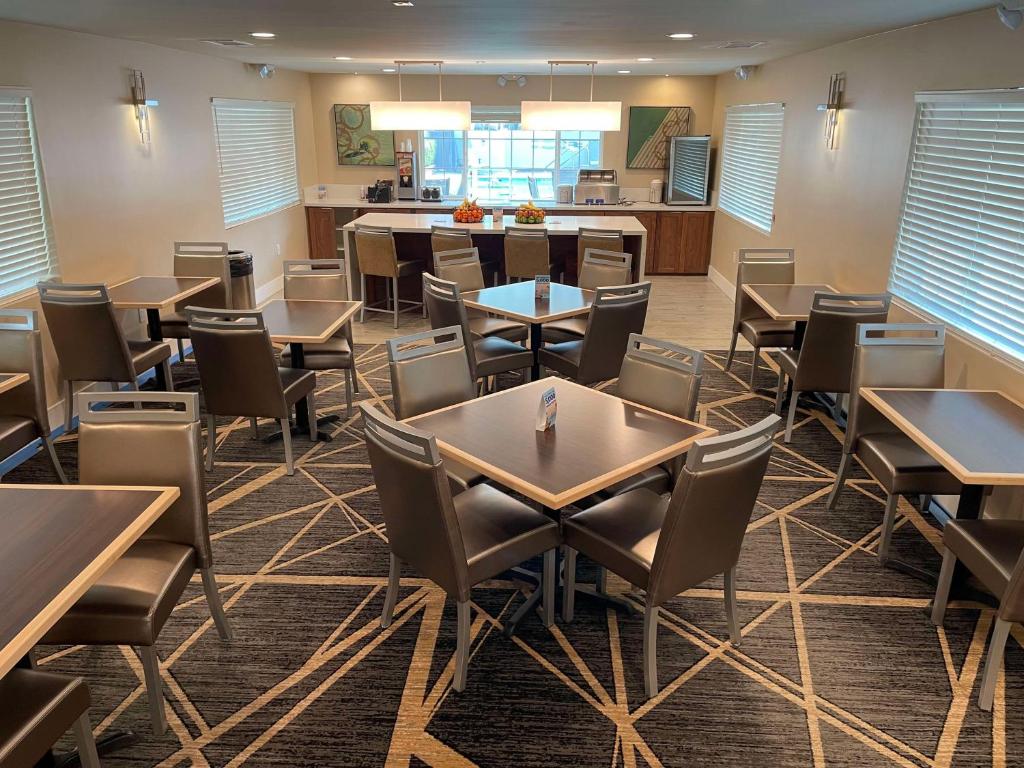 a dining room with tables and chairs and a kitchen at Best Western Town House Lodge in Modesto