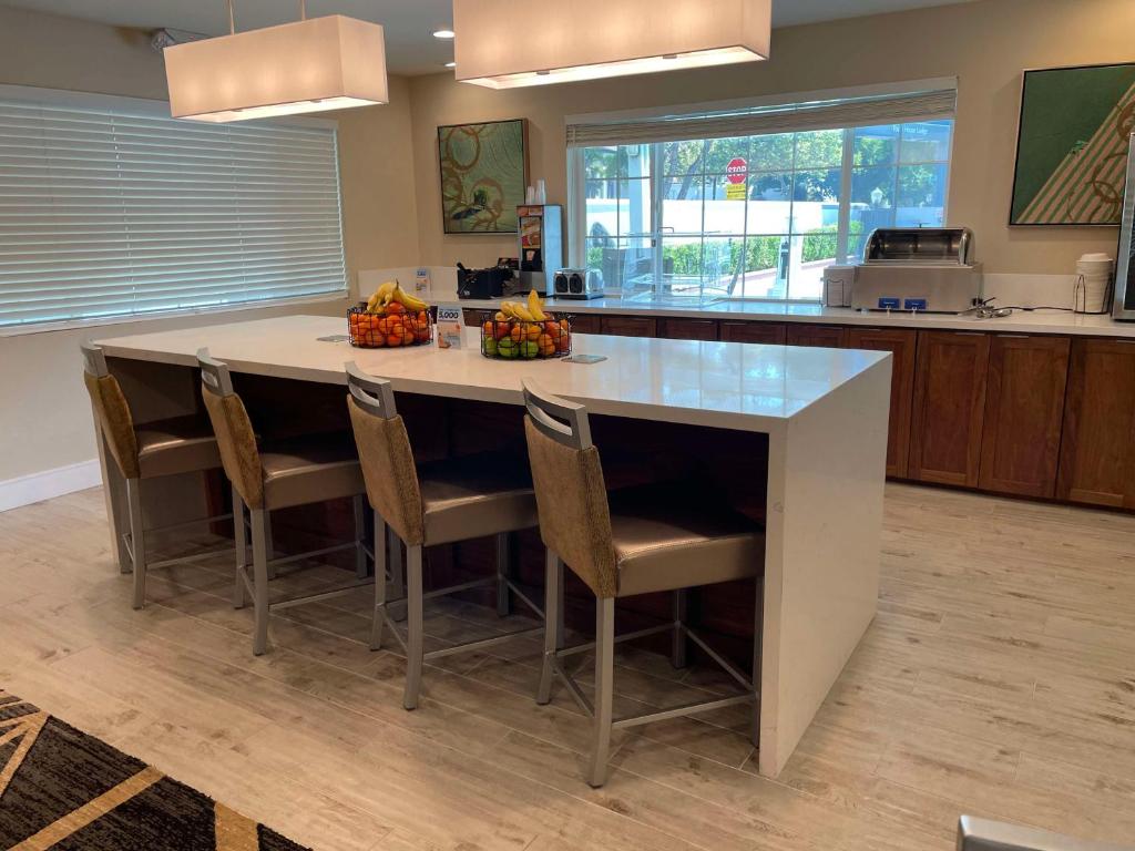 a kitchen with a large island with chairs and fruit on it at Best Western Town House Lodge in Modesto
