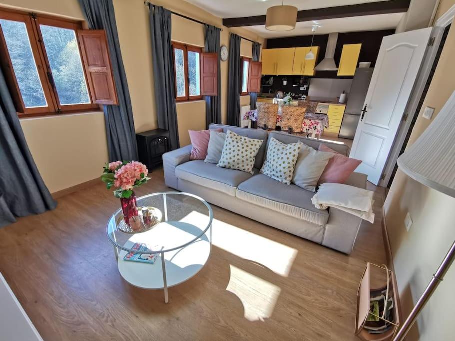 sala de estar con sofá y mesa de cristal en Casa acogedora en la naturaleza en San Martín del Rey Aurelio