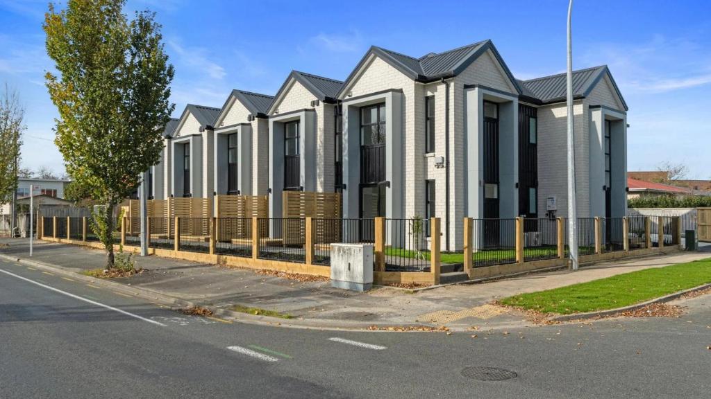 a row of houses behind a fence on a street at Norton Motel in Hamilton