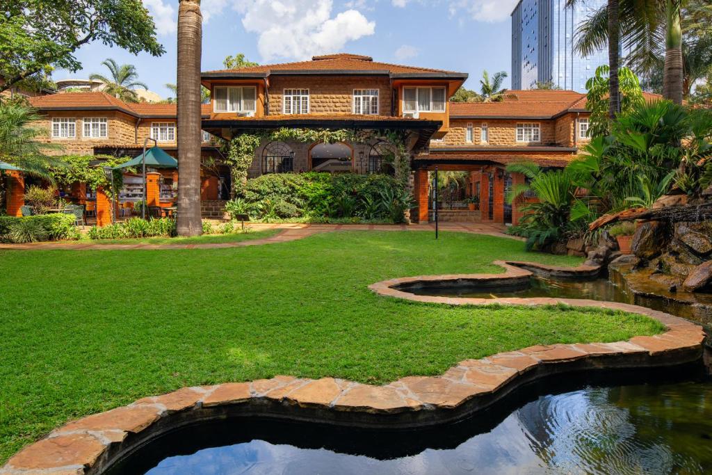a house with a pond in the yard at Fairview Hotel Nairobi in Nairobi