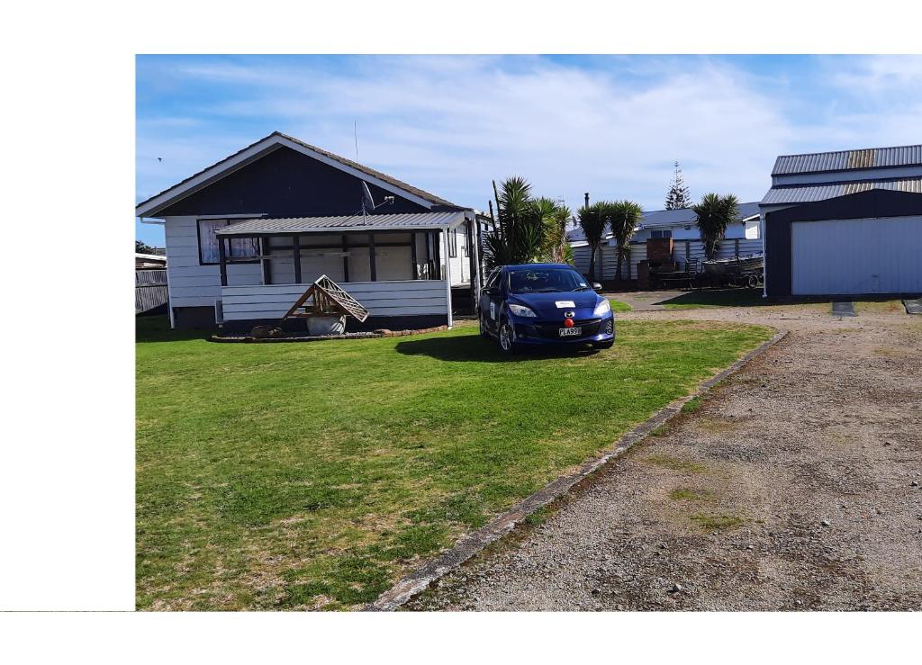 um carro azul estacionado em frente a uma casa em Anchors Away (the boaties paradise) em Whanganui