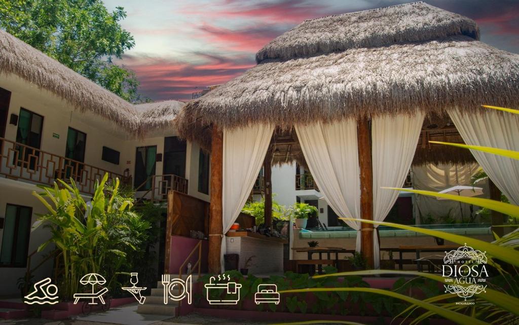 uma vista para um resort com um telhado de palha em Hotel Diosa del Agua Bacalar em Bacalar