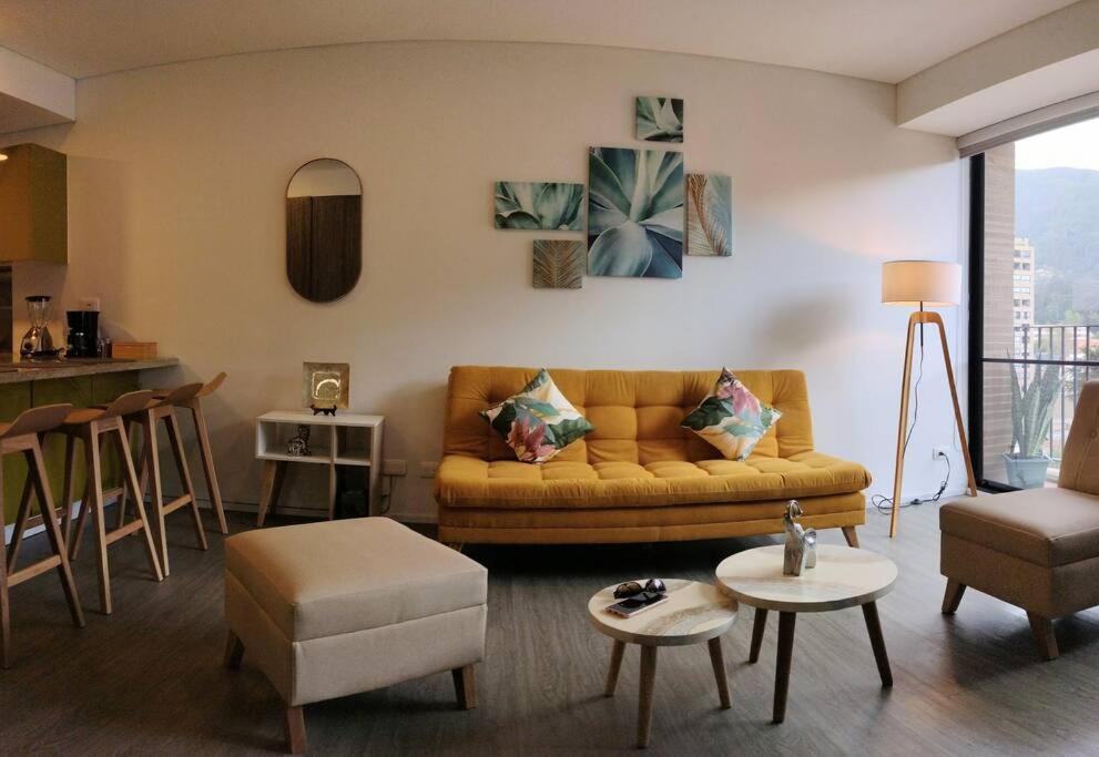 ein Wohnzimmer mit einem Sofa und einem Tisch in der Unterkunft Nuevo! Apartamento Oasis Central in Bogotá