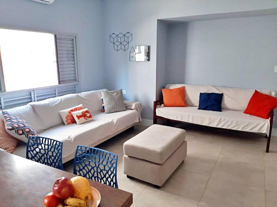 ein Wohnzimmer mit 2 Sofas und einem Tisch in der Unterkunft Apartamento charmoso no centro de Ubatuba in Ubatuba