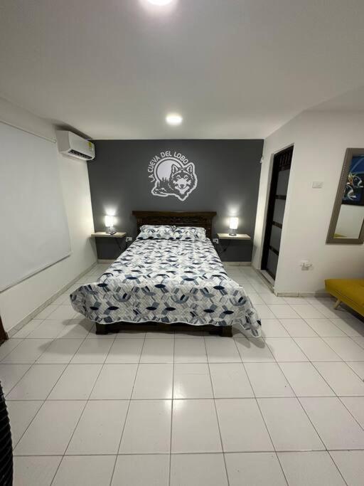 a bedroom with a bed with a comforter on it at Habitacion independiente muy bien ubicado in Cartagena de Indias