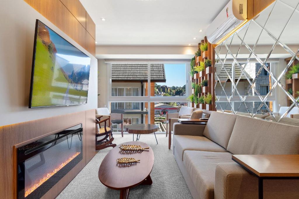 a living room with a couch and a fireplace at Vita Boulevard Luxo 2 Suítes by Achei Gramado in Gramado