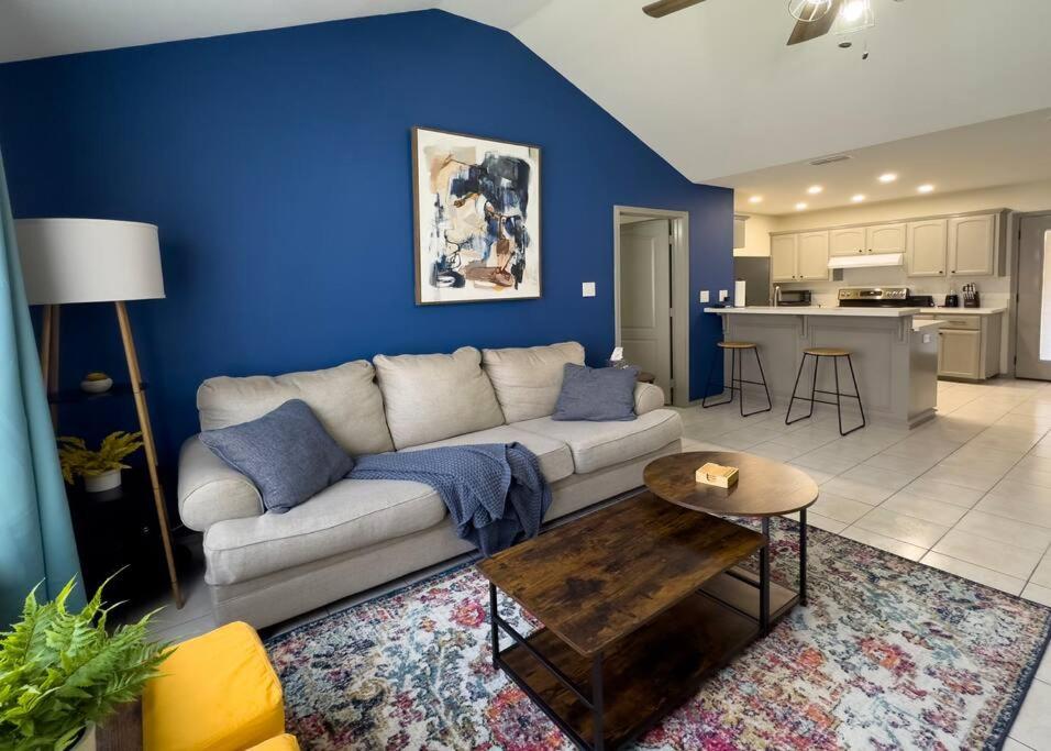 a living room with a white couch and a blue wall at Chic, Quiet 2BR 2BA Near Shops & Restos! in McAllen