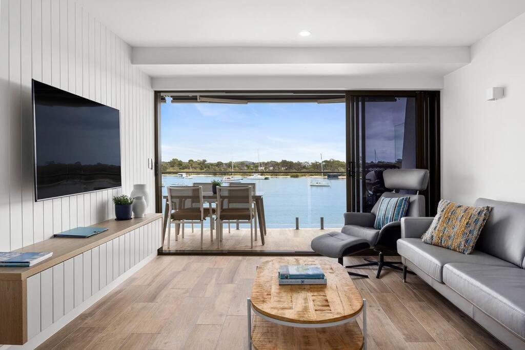 a living room with a couch and a table at Commodore Apartment 5, Noosa Heads in Noosa Heads