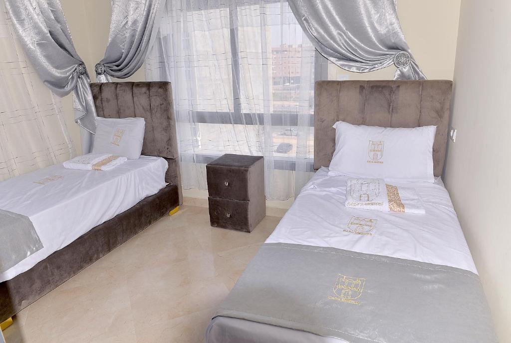 two beds in a small room with a window at Casa Hamburg in Nador
