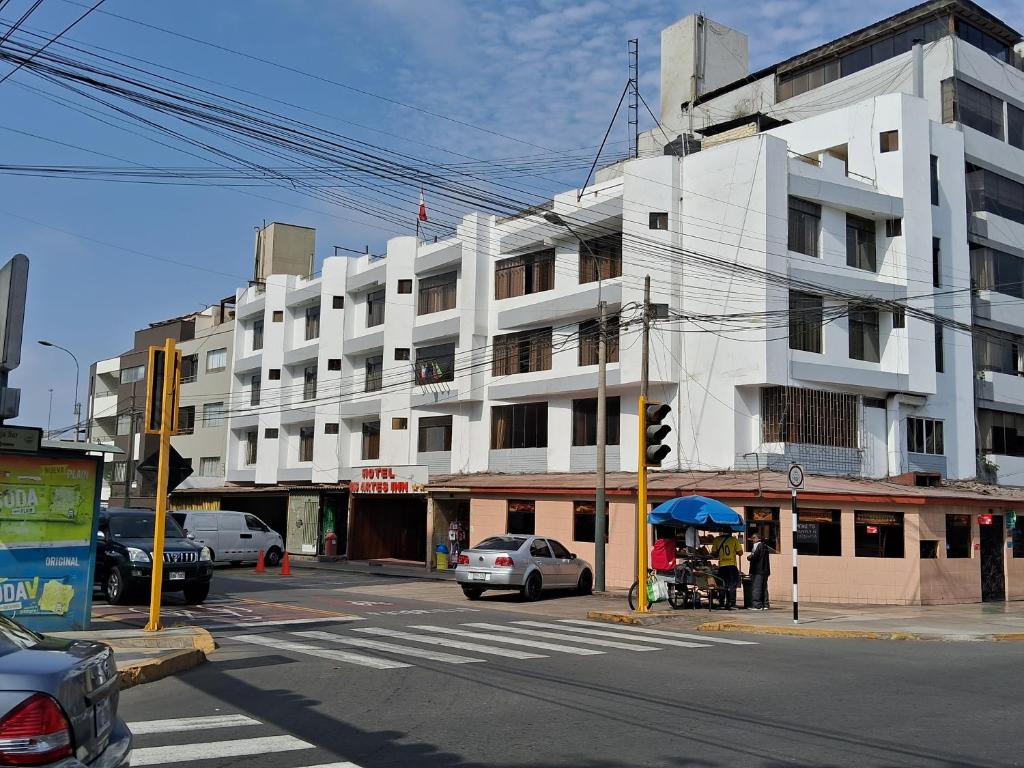 um edifício branco numa rua da cidade com um semáforo em LAS ARTES INN em Lima