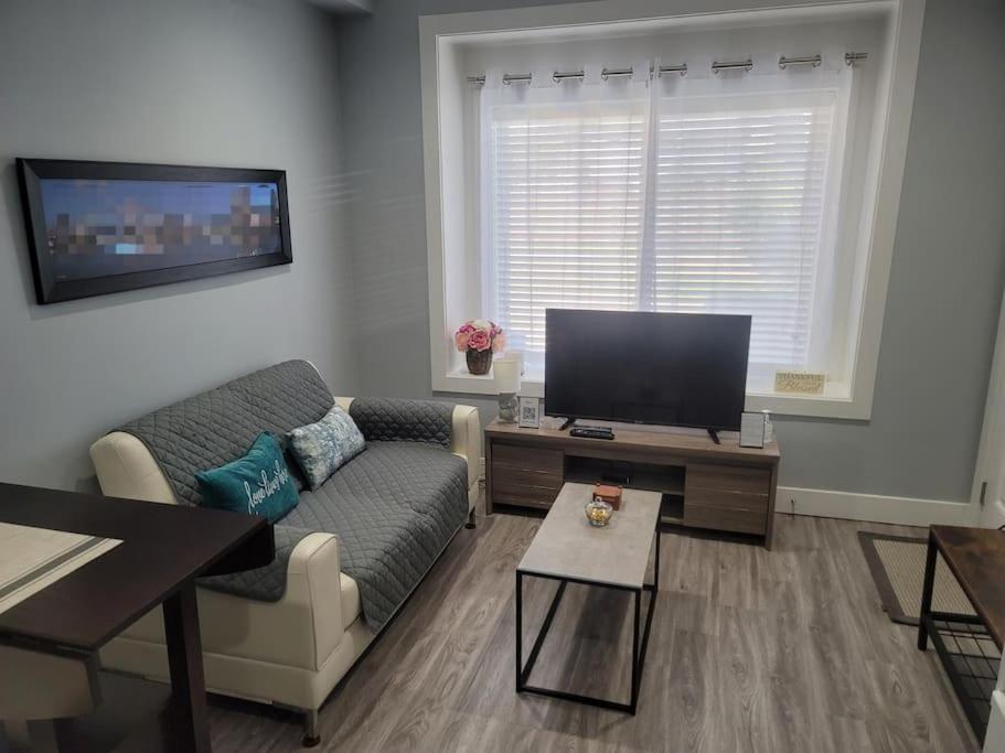 sala de estar con sofá y TV de pantalla plana en Edmonds Cove en Burnaby