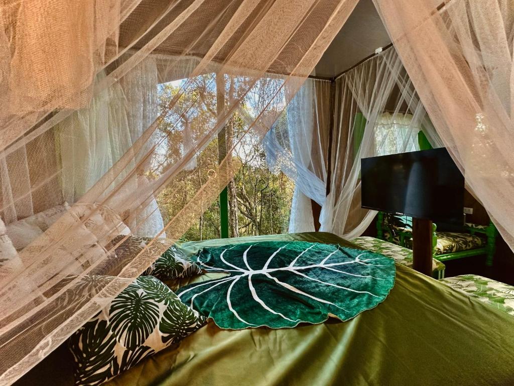 ein Schlafzimmer mit einem Himmelbett und einem Fenster in der Unterkunft Sequoia Casa na Árvore, Vila Mágica in Bueno Brandão