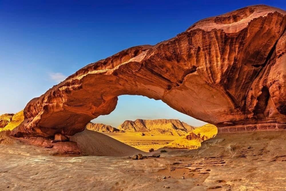 an arch in the desert with a mountain at Hilton Wadi rum in Disah