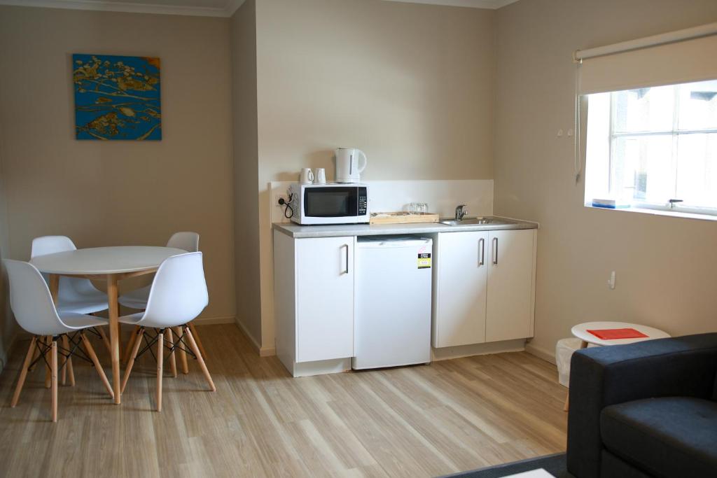 a small kitchen with a table and a microwave at Beltana Hotel in Lindisfarne