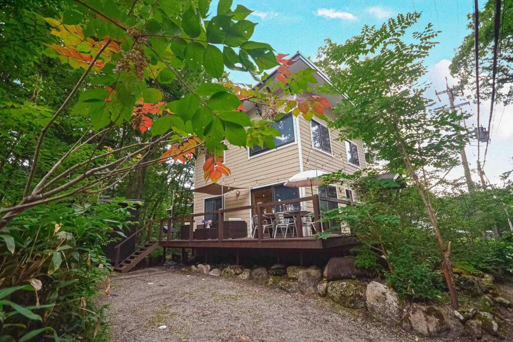a large house with a porch and a deck at Hakuba Colonsay- Amazing views 3bdr 2bth cottage in Hakuba