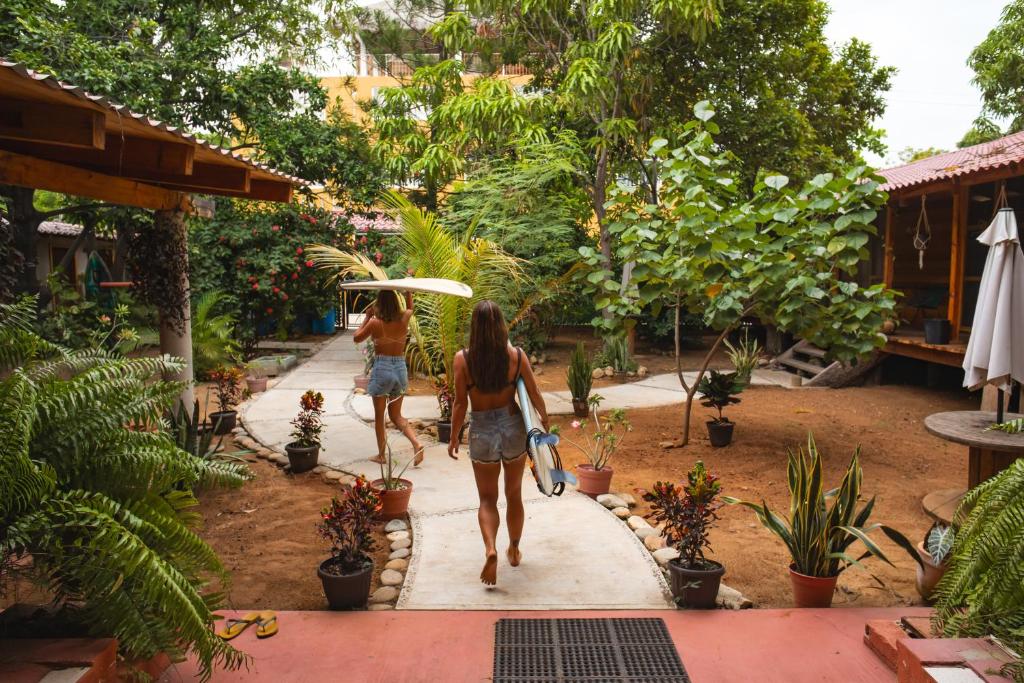 two women walking down a path in a garden at Casona H in Puerto Escondido