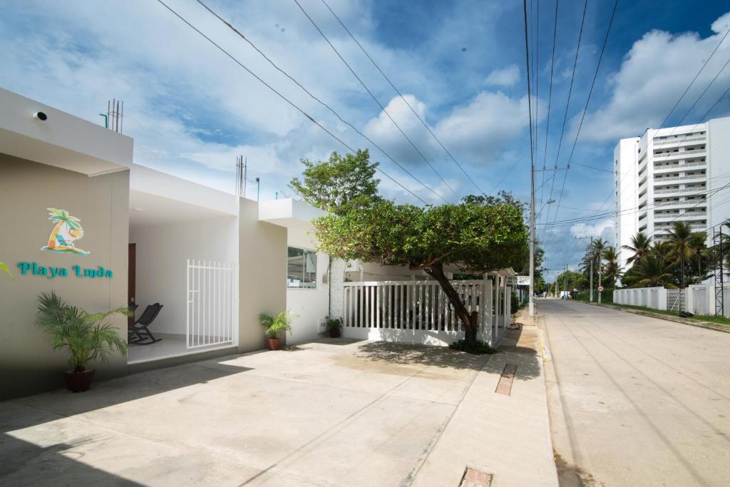 a building with a tree on the side of a street at Habitacion Playa Linda 103 in Coveñitas
