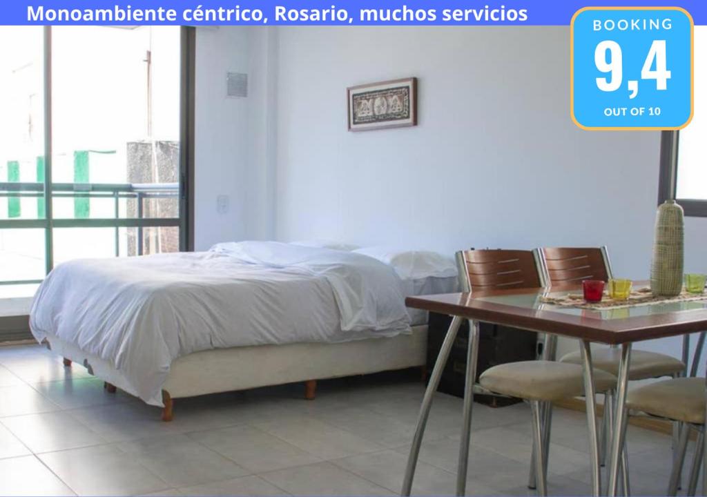 a bedroom with a bed and a table with chairs at Monoambiente Céntrico, Nuevo, Cochera y Muchos mas servicios in Rosario