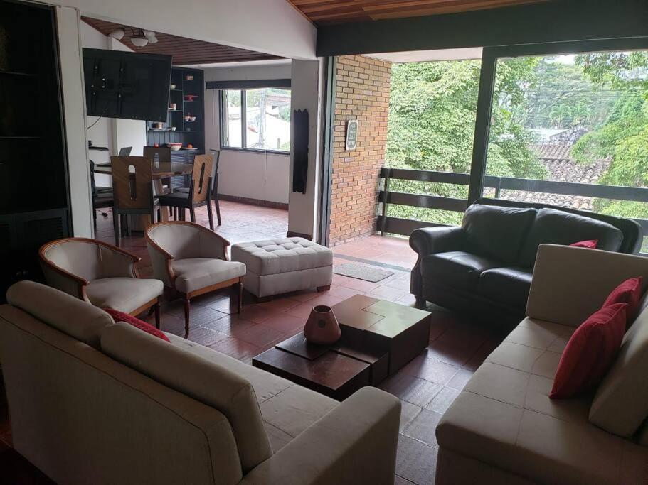 sala de estar con sofás, sillas y mesa en Apartamento enorme y acogedor en Ibagué, en Ibagué