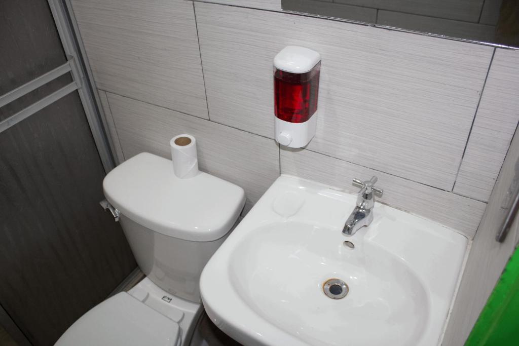 uma casa de banho com um WC branco e um lavatório. em Hotel La Castella em San José