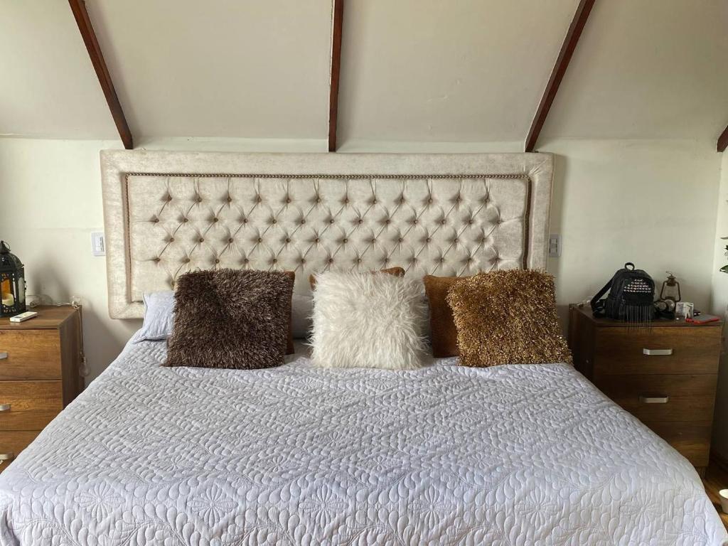 Sopetran Campestre Villa في سوبيتران: غرفة نوم بسرير ابيض عليها مخدات