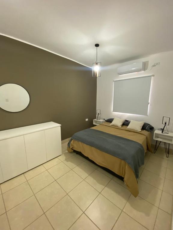 a bedroom with a large bed and a white wall at Departamento Cristo del Portezuelo I in Chilecito
