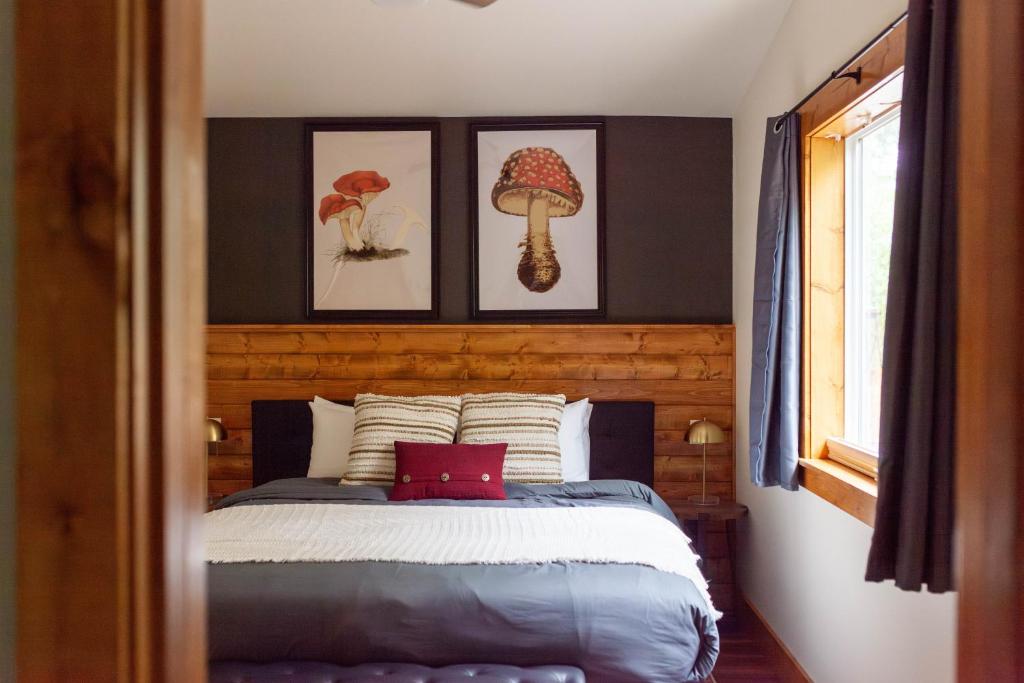 a bedroom with a bed with three pictures on the wall at Backwoods Cabins in Carson