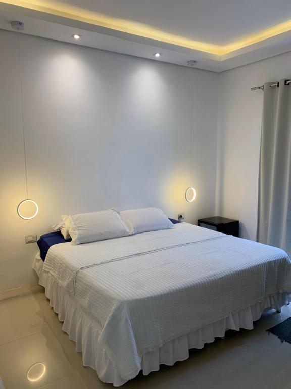 a bedroom with a large white bed with lights on it at Habitación en suite in Fernando de la Mora