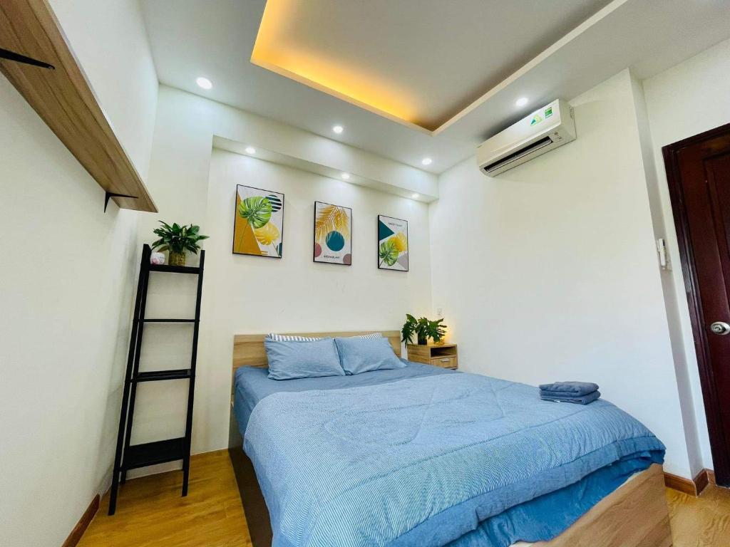 a bedroom with a blue bed in a room at Ule Home in Ho Chi Minh City