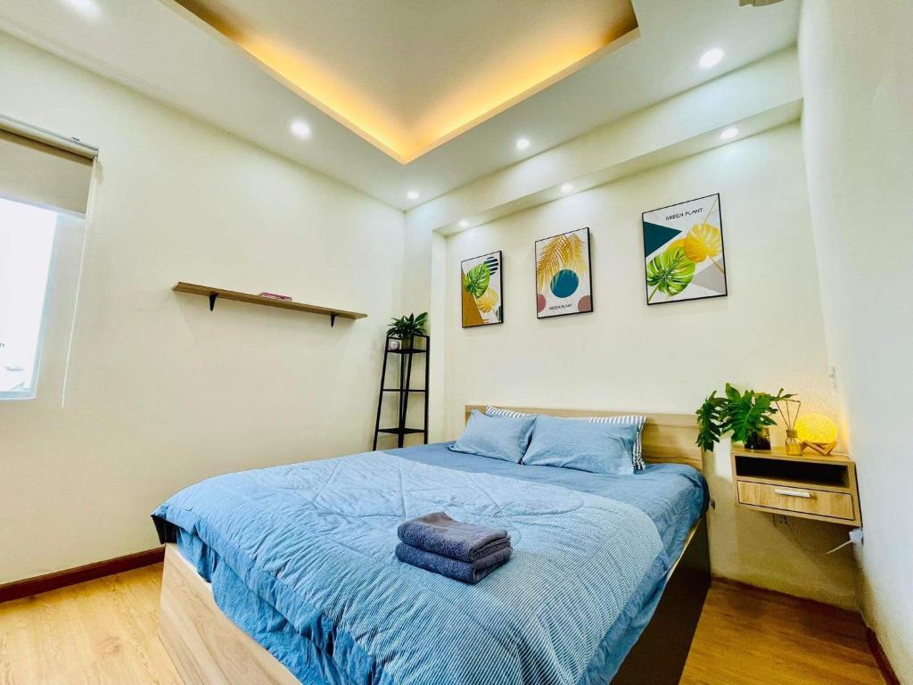 a bedroom with a bed with a blue comforter at Ule Home in Ho Chi Minh City