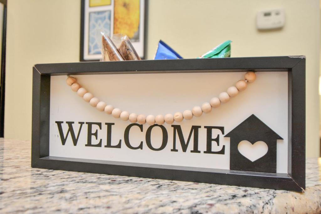 a welcome sign in a black frame on a table at NASA Solace Getaway-King Bed in Houston