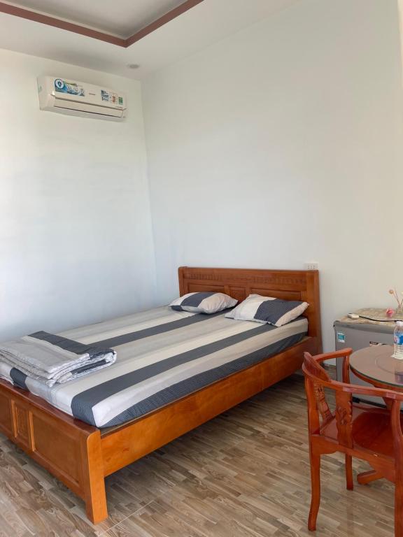 Schlafzimmer mit einem Bett, einem Tisch und einem Tisch in der Unterkunft Nhà Nghỉ MoTel Thúy Linh in Ấp Mỹ Hải