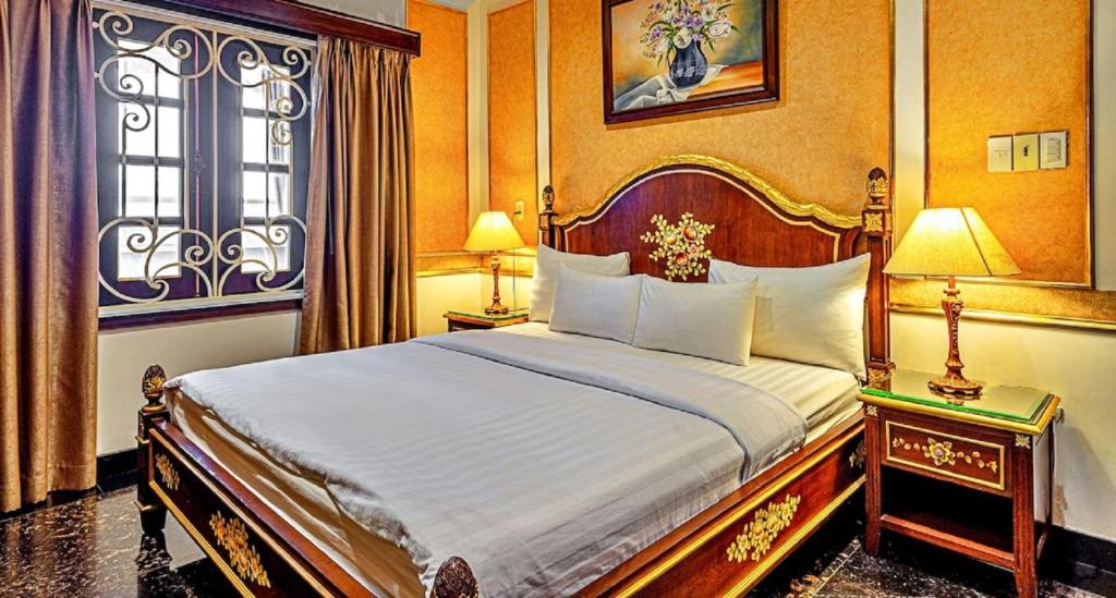 a bedroom with a bed and two lamps and a window at 345AB Sai Gon Hotel in Ho Chi Minh City