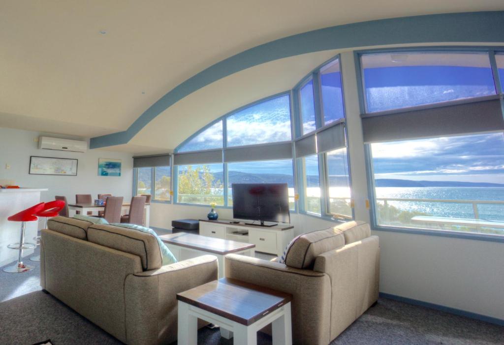 a living room with two couches and a large window at Pierview Apartments in Lorne