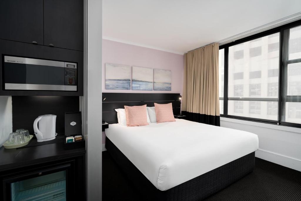 een hotelkamer met een wit bed en een raam bij Park Regis City Centre in Sydney