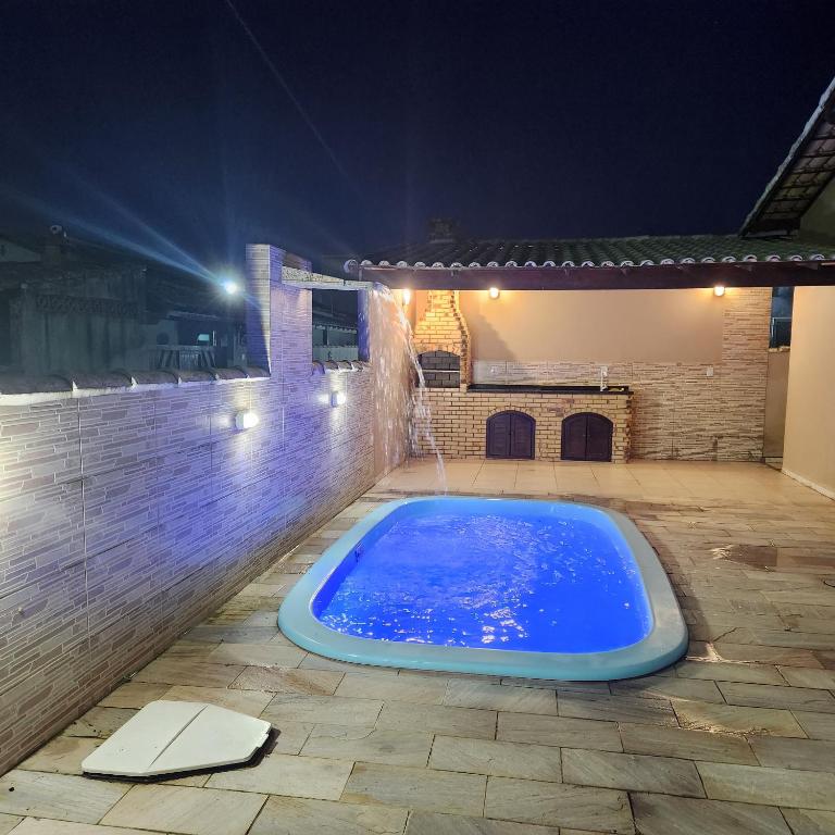 a swimming pool in a backyard at night at Casa Recanto de Unamar in Cabo Frio