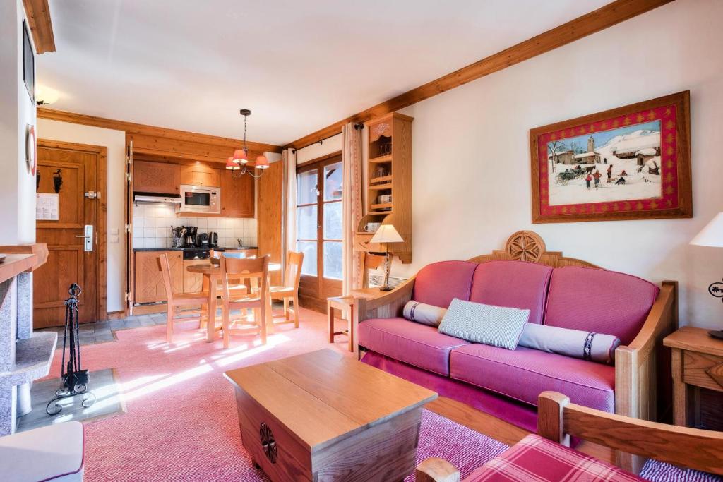 a living room with a purple couch and a table at Résidence Les Arcs Le Village - maeva Home - Appartement pièces - Prestige 134 in Bourg-Saint-Maurice