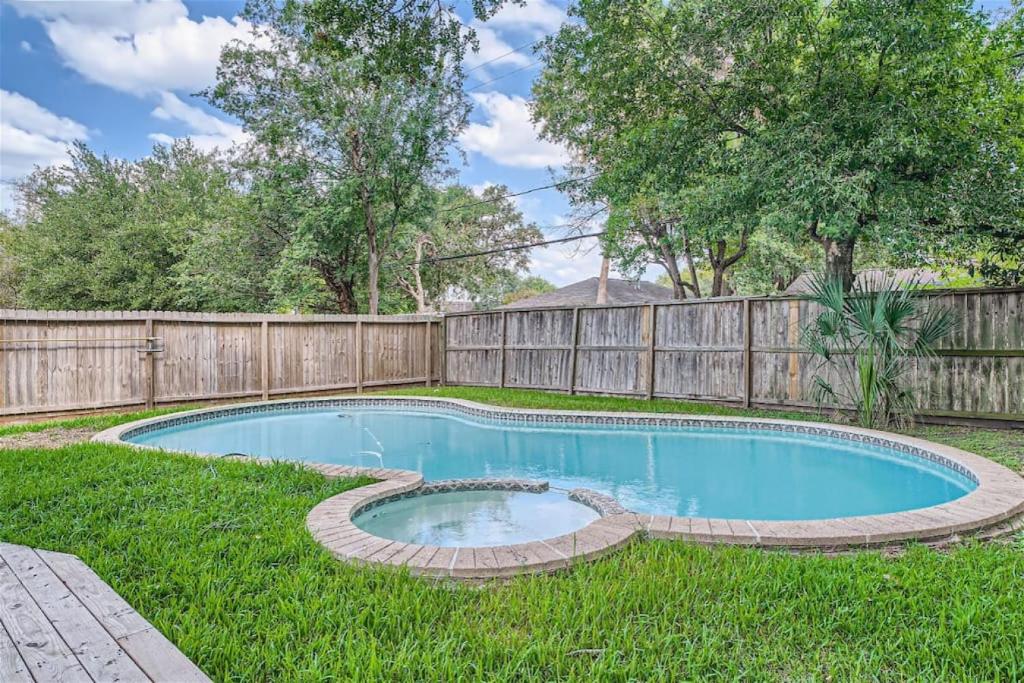 a swimming pool in a yard with a fence at Elegant 3BR Bungalow Oasis plus Pool in Prime Locations in Houston