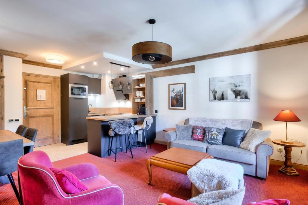 un salon avec un canapé et des chaises et une cuisine dans l'établissement Résidence Les Arcs 1950 Le Village - maeva Home - 3 Pièces 6 Personnes Prestige - Prince des Cîmes MAE-5948, à Bourg-Saint-Maurice