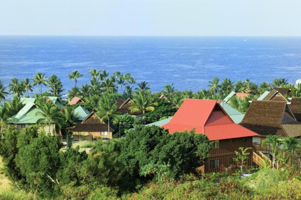 Club Wyndham Kona Hawaiian Resort في كيلوا كونا: مجموعة من المنازل مع المحيط في الخلفية