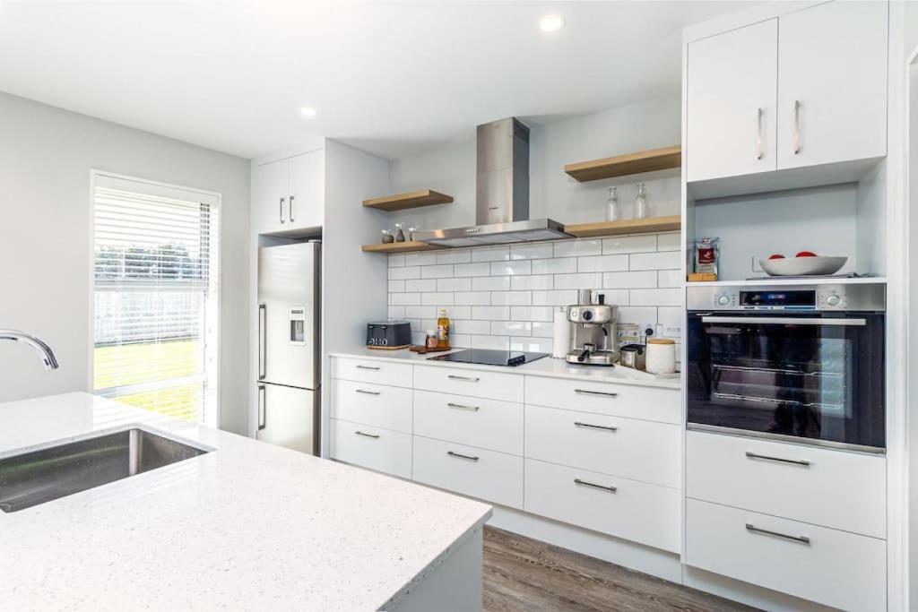 a kitchen with white cabinets and a stove top oven at Home away from home Methven in Methven